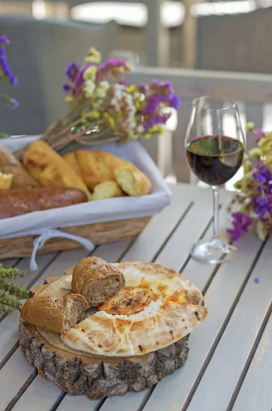 Белый французский хлеб на деревянной доске со стеклом вина — стоковое фото