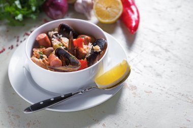 Paella safran pirinç, bezelye, karides, midye, mürekkep balığı, et ile beyaz tabak içinde. Deniz ürünleri paella, geleneksel İspanyol yemeği.