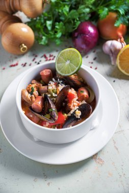 Paella safran pirinç, bezelye, karides, midye, mürekkep balığı, et ile beyaz tabak içinde. Deniz ürünleri paella, geleneksel İspanyol yemeği.