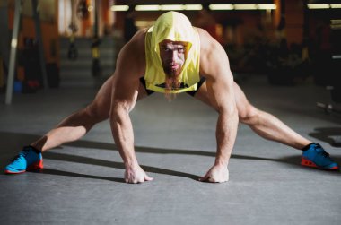 Spor salonunda esneme egzersizleri yapan bir fitness oyuncusunun portresi.