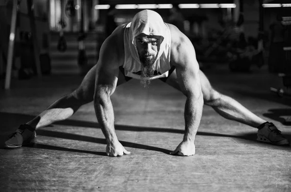 Portrait of a fitness man doing stretching exercises at gym — Stock Photo, Image