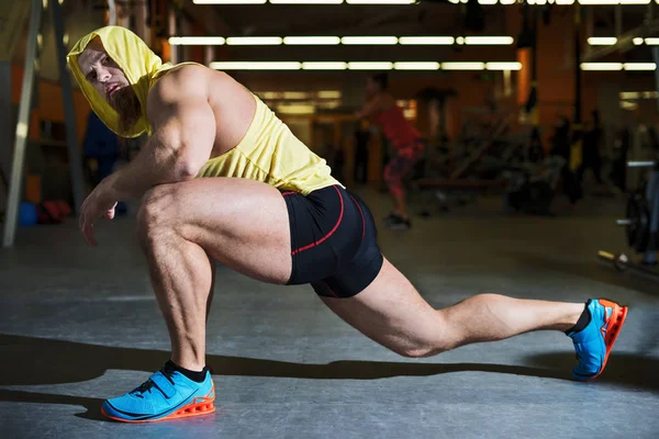 Portrait d'un homme de fitness faisant des exercices d'étirement à la salle de gym — Photo