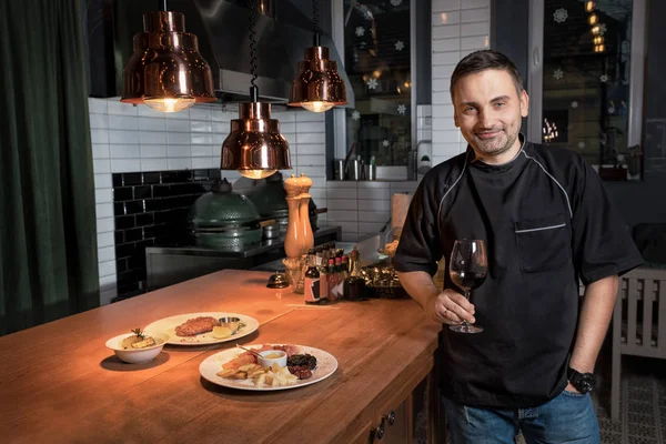 Chef cocinero celebrar copa de vino tinto en el restaurante bar — Foto de Stock