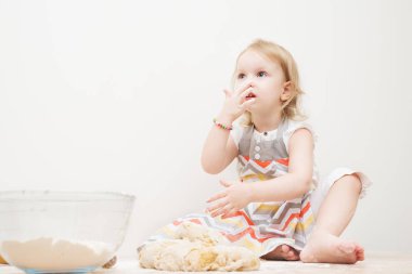 Güzel küçük kız mutfakta yemek yapmayı öğreniyor.