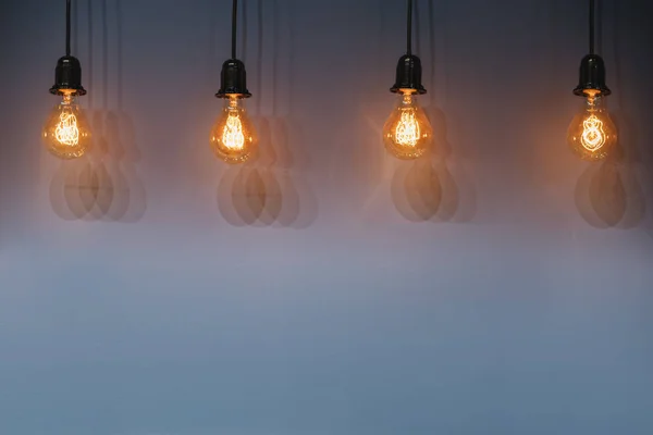 Decorative antique edison style light bulbs against wall background. — Stock Photo, Image