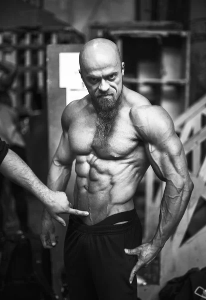 Bodybuilding contest behind the scenes: the contestant is preparing for the performance. Selective focus. — Stock Photo, Image