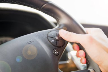 Adam el arabada direksiyon simidi üzerinde telefon düğmesine basarak