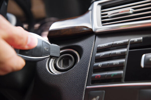 Person's Hand Inserting Key To Start Car