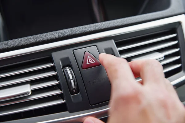 Hombre pulsando botón de luz de emergencia mientras conduce el coche — Foto de Stock