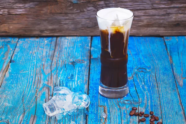 Iced coffee with whipped milk and caramel ice cream in tall glasses on rustic wooden table. — Stock Photo, Image