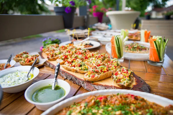 Mesa de madera en la calle en un café con comida, concepto de terraza al aire libre de una mesa buffet, catering . —  Fotos de Stock