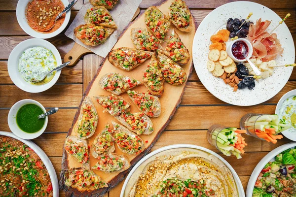 Mesa de madera en la calle en un café con comida, concepto de terraza al aire libre de una mesa buffet, catering . — Foto de Stock