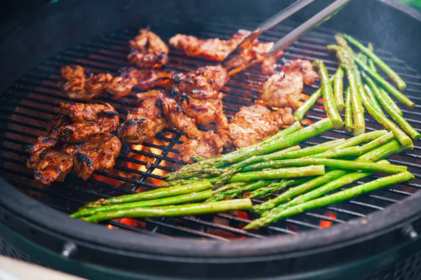 Saftig köttbit matlagning på en grill med en sida av sparris. Äta begreppet näring. Frukostbuffé. Mat. — Stockfoto