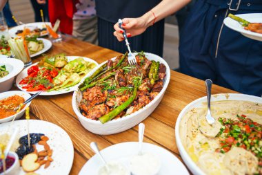 Kadınların elleri kendilerini tabakta yemek bir yemek kazık. Beslenme kavramı. Açık büfe. Gıda. Akşam yemeği. Paylaşımı kavramının.