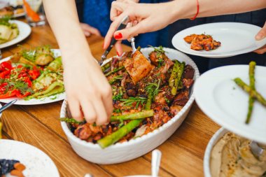 Kadınların elleri kendilerini tabakta yemek bir yemek kazık. Beslenme kavramı. Açık büfe. Gıda. Akşam yemeği. Paylaşımı kavramının.
