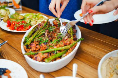 Kadınların elleri kendilerini tabakta yemek bir yemek kazık. Beslenme kavramı. Açık büfe. Gıda. Akşam yemeği. Paylaşımı kavramının.