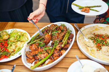 Kadınların elleri kendilerini tabakta yemek bir yemek kazık. Beslenme kavramı. Açık büfe. Gıda. Akşam yemeği. Paylaşımı kavramının.