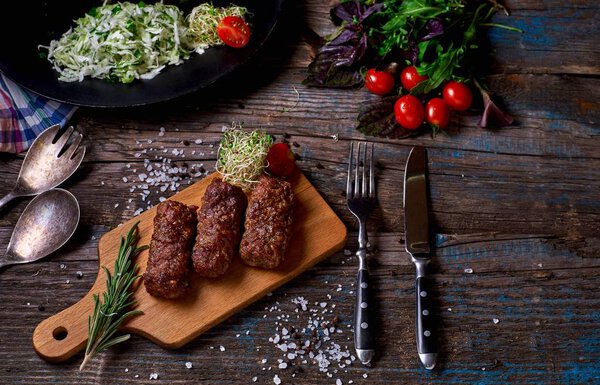 Products grill: steak, sausage and vegetable on a rustic wooden table. Sausages on the grill pan on the wooden background. Horizontal a copy space.