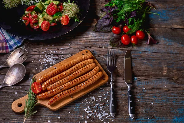 Felülnézet colorfuls sült kolbász és a zöldség egy rusztikus, fából készült asztal. A grill kolbász pan, a fából készült háttér. Szemközti nézet. — Stock Fotó