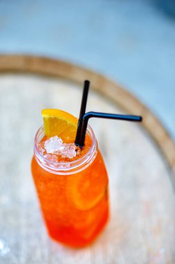 Kokteyl Aperol-Spritz. Turuncu bir kama ile bir plastik bardak ve
