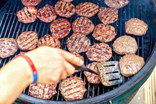 Sertéshús és az csirke burgers, a lángok és a füst a grillezés — Stock Fotó