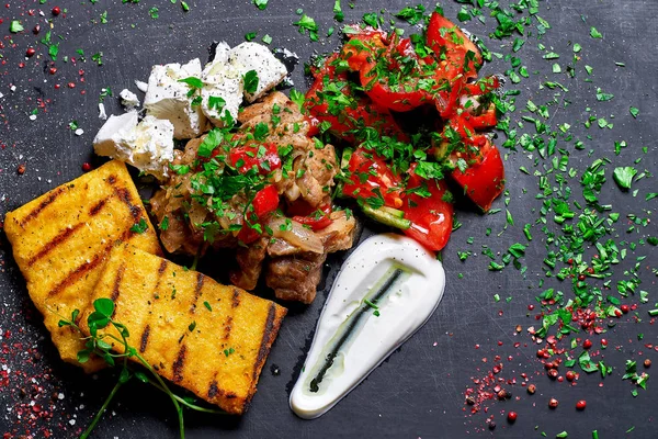 Hominy com carne ensopada de porco, carne bovina e salada em uma placa preta. Menu de restaurante. Espaço livre para texto . — Fotografia de Stock