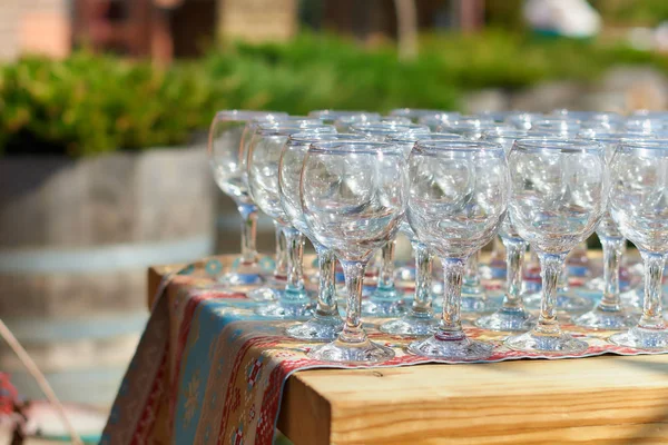 Υπέροχος πίνακας γυαλιά κρασιού glassestwo σειρές από γυαλιά σε ένα τραπέζι με ένα λευκό tableclothglasses σε υψηλές legsplaced ένα ποτήρι κρασί στο εορταστικό τραπέζι — Φωτογραφία Αρχείου