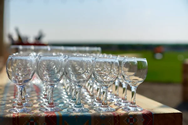 Υπέροχος πίνακας γυαλιά κρασιού glassestwo σειρές από γυαλιά σε ένα τραπέζι με ένα λευκό tableclothglasses σε υψηλές legsplaced ένα ποτήρι κρασί στο εορταστικό τραπέζι — Φωτογραφία Αρχείου