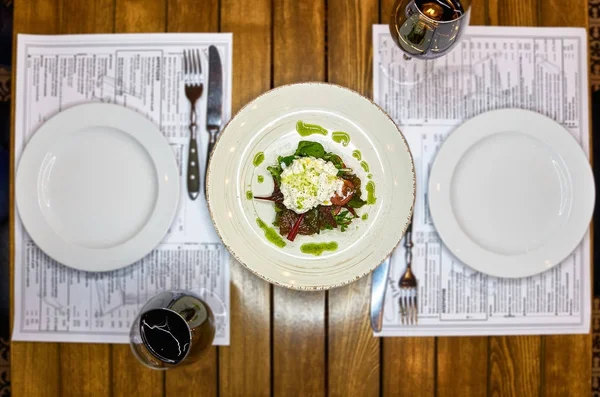 Especialidad italiana tradicional Queso Burrata en plato de cerámica servido con aceite de oliva y ensalada verde sobre una mesa de madera rústica blanca . — Foto de Stock