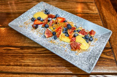 Orman, kış meyveleri ile krem Sabayon. Hafif tatlı bir plaka üzerinde beyaz şarap ile. Ahşap arka plan.