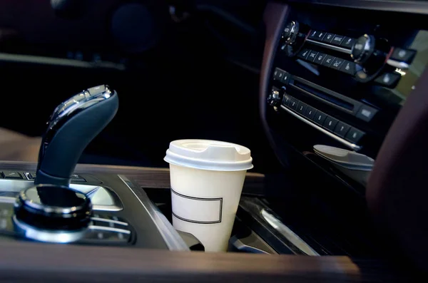 Kaffee im Autosalon. eine einzelne Kaffeetasse aus Papier im Becherhalter. Stockbild
