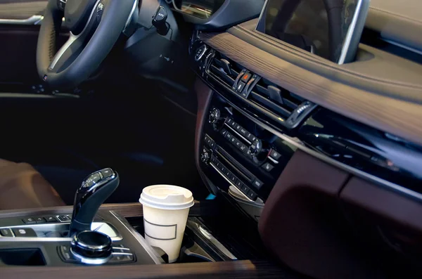 Kaffee im Autosalon. eine einzelne Kaffeetasse aus Papier im Becherhalter. Stockbild