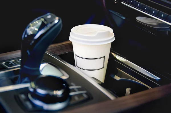 Kaffee im Autosalon. eine einzelne Kaffeetasse aus Papier im Becherhalter. lizenzfreie Stockfotos
