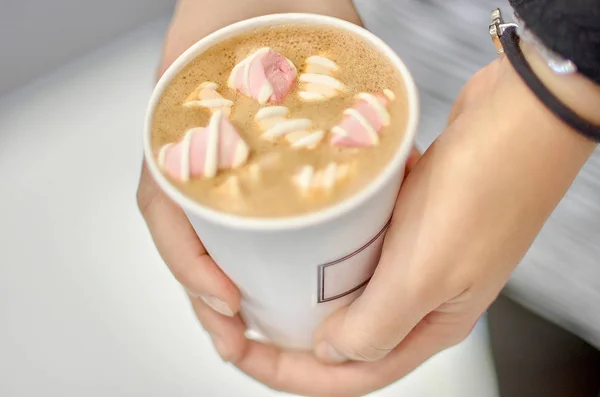 Female hands holding pink cup of coffee with marshmallow — Stock Photo, Image
