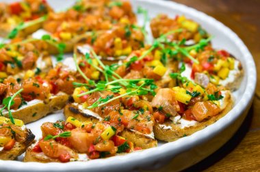 Bruschetta, meze ve farklı sos içeren tablo açık büfe. Humus, sığır eti, pate, avokado, domates ile. ahşap rustik masaya.