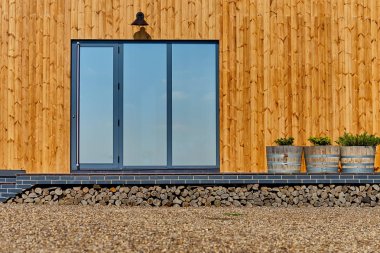 Ahşap ev ahşap cephe. Sarı ahşap planking. Panorama windows. Mükemmel görünüm yansıma bir mavi gökyüzü pencerede.