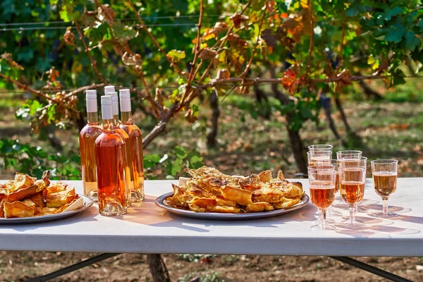 Erfrischenden rosa Wein in einem Glas mit Kuchen auf einem Tisch, vor dem Hintergrund eines Weinbergs. das Konzept der Weinbereitung. — Stockfoto
