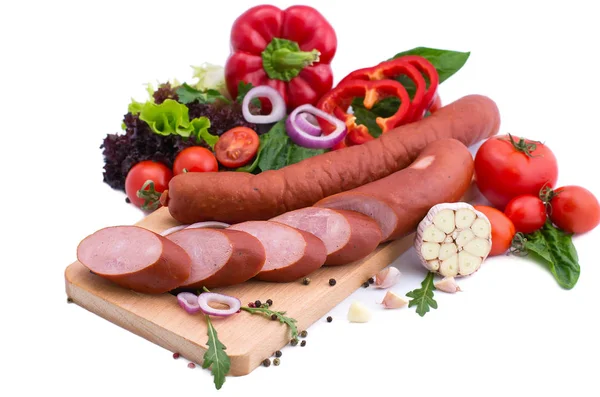 Rå korv, sallad, röd paprika och tomater på en träskiva. Kött sammansättning på en vit bakgrund. — Stockfoto