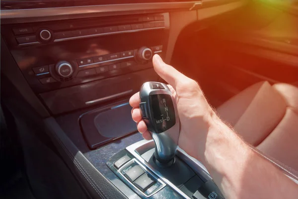 Man's hand on an automatic gearbox. Automatic shift transmission. Sunlight. — Stock Photo, Image