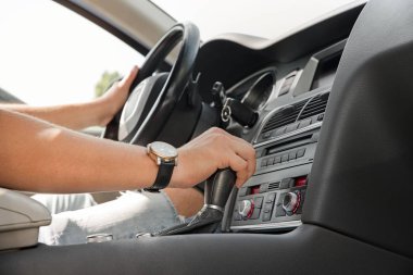 adamın elinde bir otomatik vites. Otomatik kaydırma iletim. Güneş ışığı.