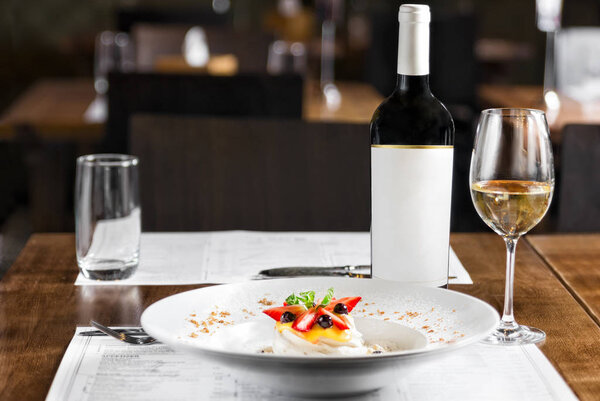 Anna Pavlova dessert, zephyr with berries and whipped cream on a wooden table