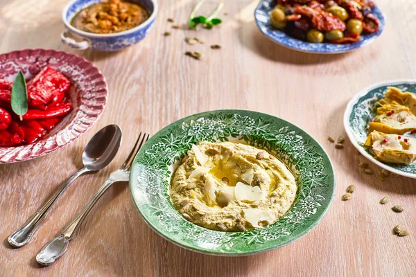 Cuencos de hummus diferentes. Hummus garbanzo, hummus lentejas y verduras en escabeche en mesa de madera — Foto de Stock