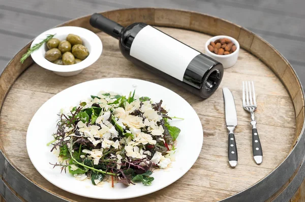 Botella de vino. Ensalada verde fresca con remolacha, queso de cabra y aceite de oliva, alimentos saludables, ecológicos — Foto de Stock