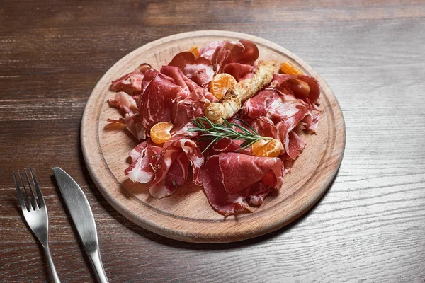 Fa vágódeszka, fából készült asztal hátsó prosciutto sajttal — Stock Fotó