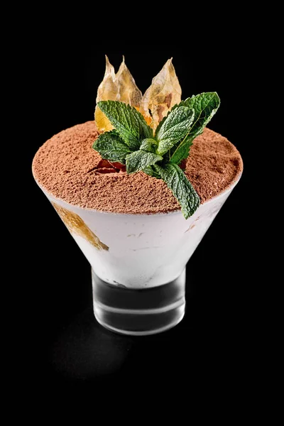 Sobremesa tradicional italiana Tiramisu doce em um copo witn folhas de hortelã e cacau no fundo escuro — Fotografia de Stock