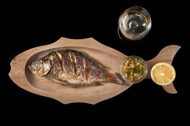 Fried Dorado balık limonlu ve siyah bir zemin üzerine beyaz şarap. Kopya alanı.