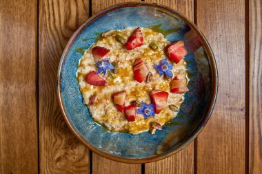 Kahvaltıda böğürtlen ve karamel. Yulaf ezmesi veya çilekli tahıl gevreği. Üst görünüm, alanı kopyala.