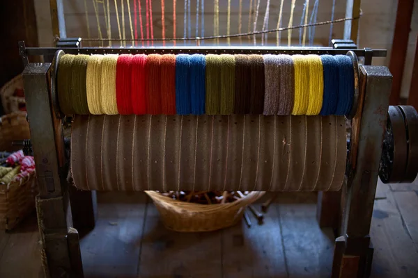 colored woolen threads on an old loom, Traditional Yarn in Canada.