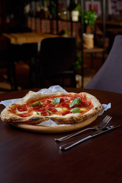 Концепция питания. Свежая итальянская пицца на деревянной доске в итальянской пиццерии или ресторане
.