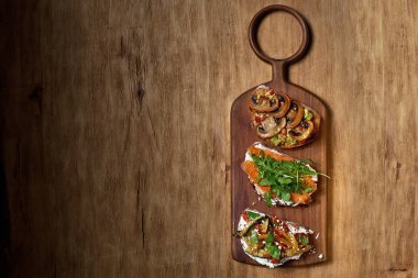 İtalyan bruschetta 'sı ya da tepside sandviç ve taze yaz yemekleri için ahşap arka plan. Üst Görünüm